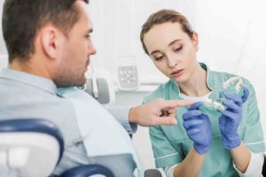 Kieferorthopäde bespricht Zahnspangenplan mit Patient