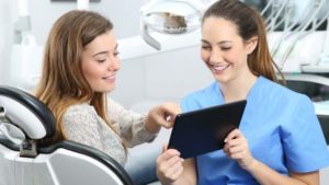 Kieferorthopäde zeigt Patient die Kostenübernahme durch dir Krankenkasse