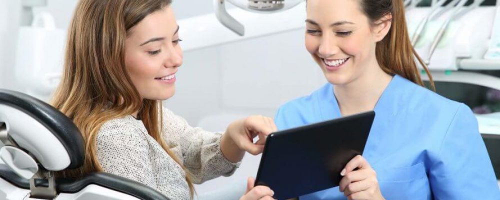 Kieferorthopäde zeigt Patient die Kostenübernahme durch dir Krankenkasse